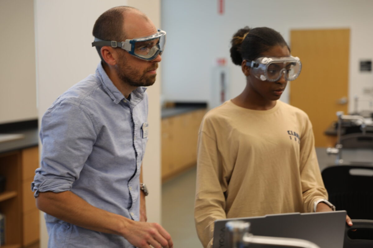 A male teacher discussing the results of an experiment with a student. - Full Size