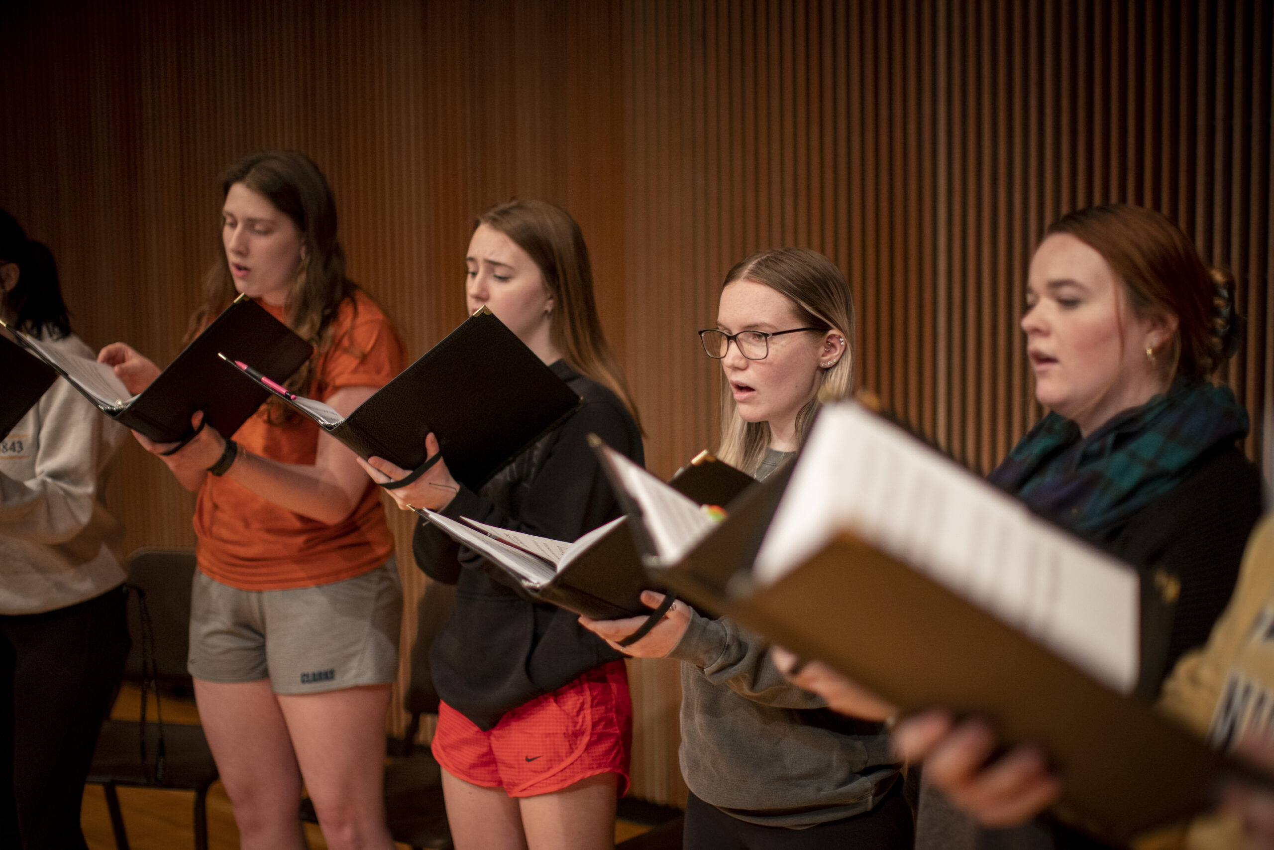 A group of female students singing in a choir.