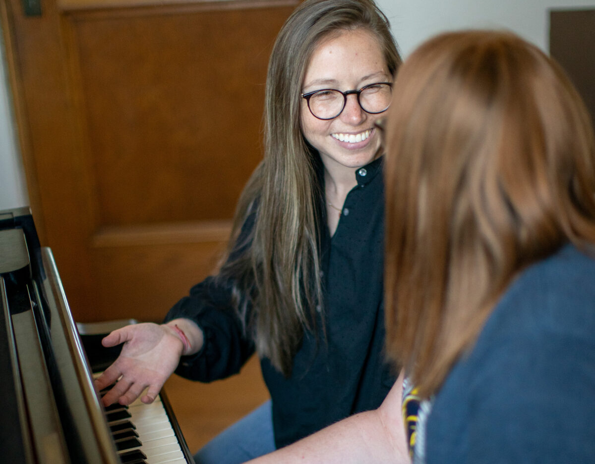 A female professor instructing a student at a piano. - Full Size