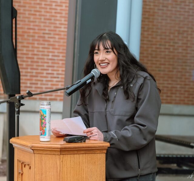 Female student speaking at a podium