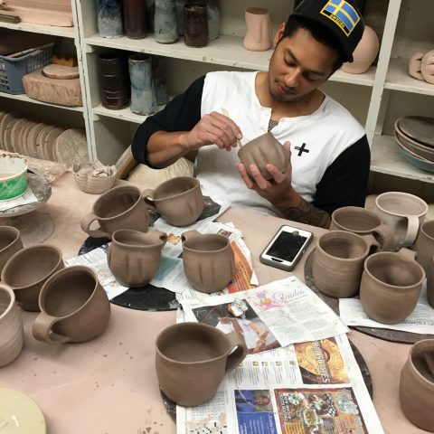 Erik Brolin puts on the finishing touches to his ceramic mugs.