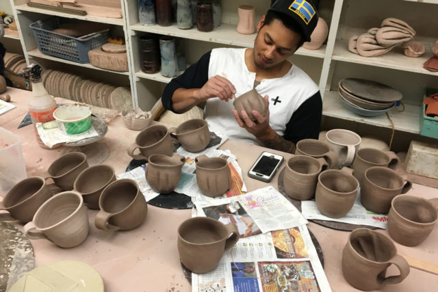 Erik Brolin puts on the finishing touches to his ceramic mugs.