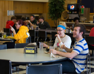 Clarke students laughing while eating at the dining hall