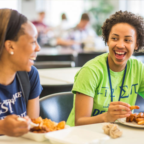Clarke students laughing while eating at the dining hall