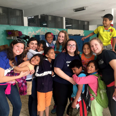 Clarke students with children while studying abroad in Equcador
