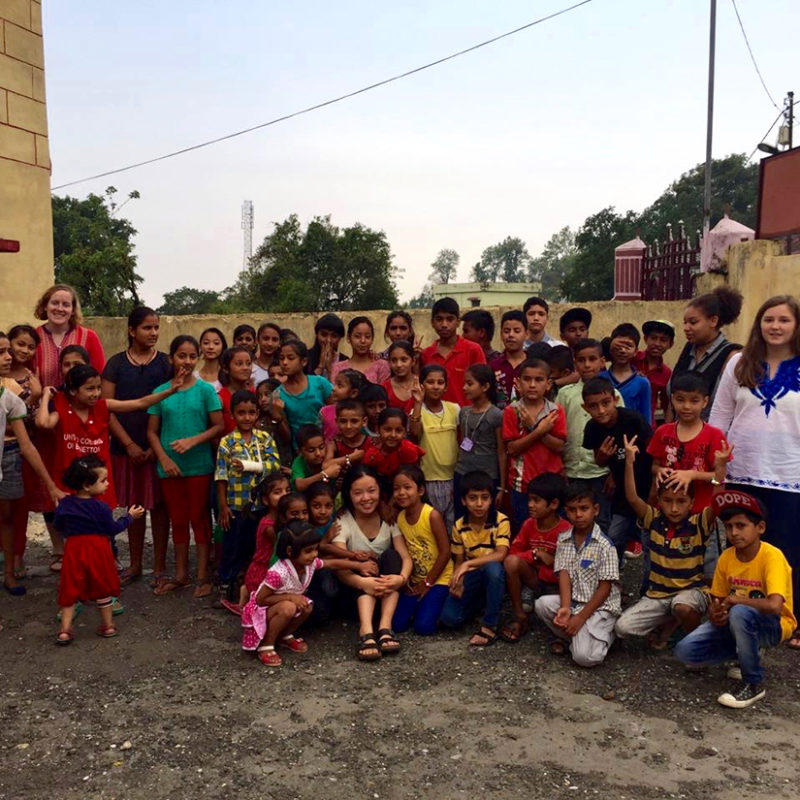 Clarke students with children while studying abroad in India